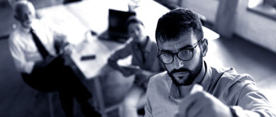 man writing on white board during meeting in conference room