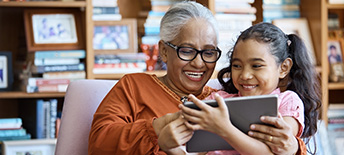 grandmother and granddaughter sitting together laughing