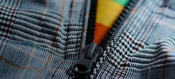 Zipper unzipping revealing a rainbow patterened shirt