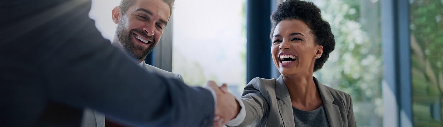 Executives laughing and shaking hands