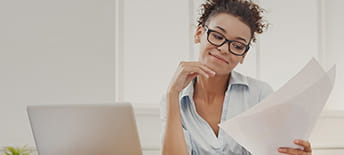 woman wearing glasses looking at paperwork