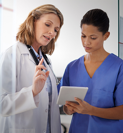 doctor and nurse discussing looking at a tablet